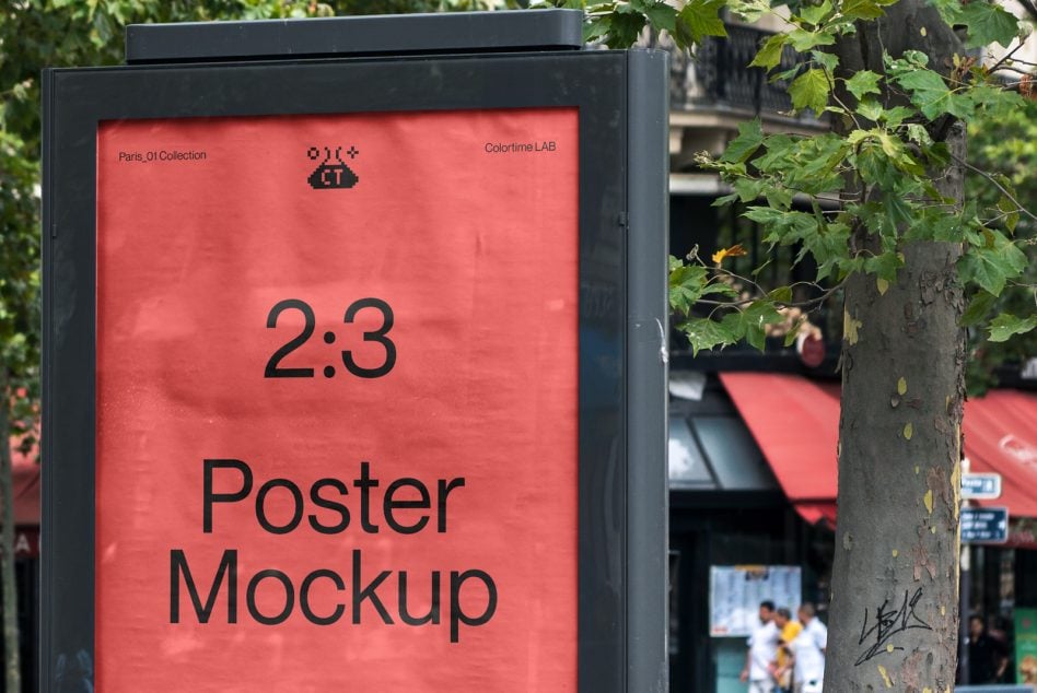 Red street kiosk display with black text reading 2:3 Poster Mockup surrounded by green foliage